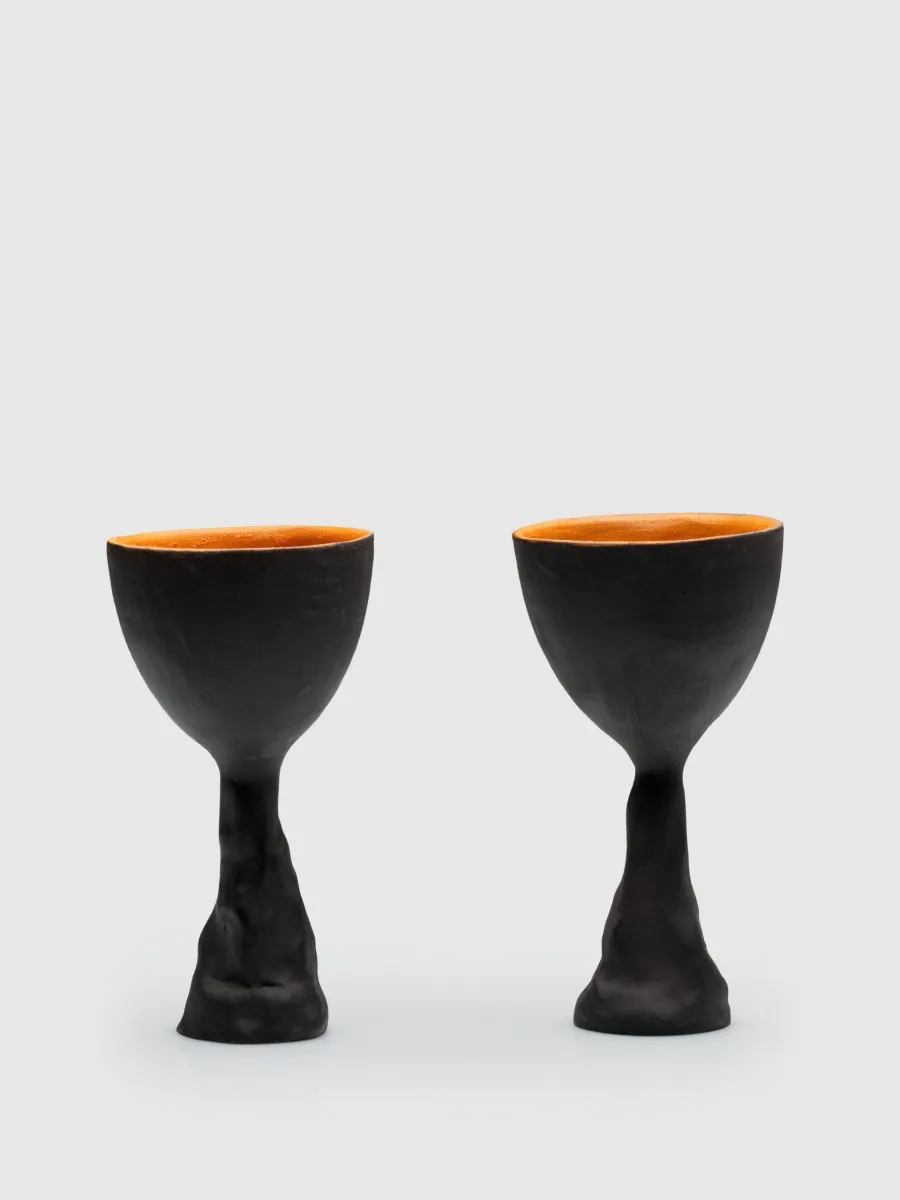 Two Kings' Goblets with sculpted black stems on a light background