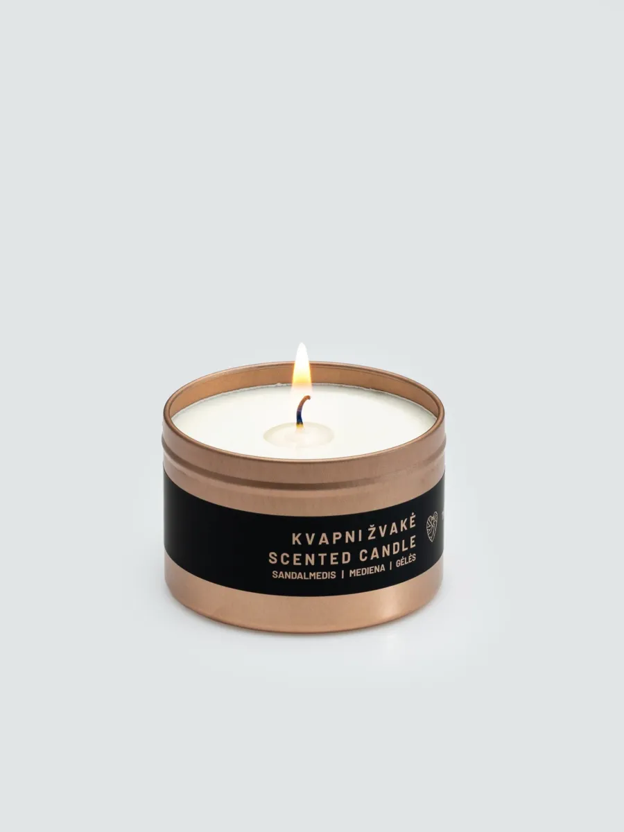 Lit small “Little Slapta meilė” candle in a copper-coloured tin with a black label on a light background