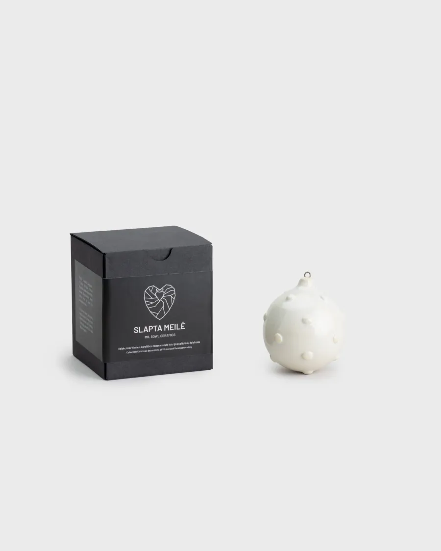 “Royal Pearl” Christmas ornament next to a black “Slapta meilė” box