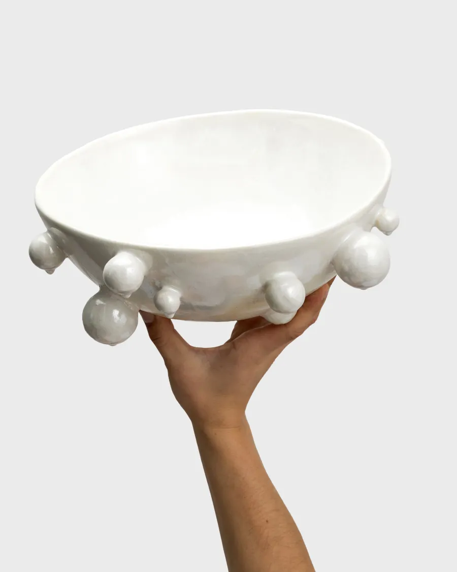 Medium pearl white “The Queen's Pearl Bowl” held in one hand