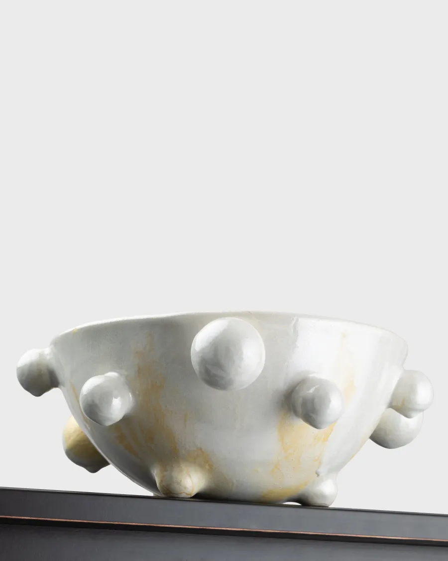Side of a medium pearl white “The Queen's Pearl Bowl” on the edge of a shelf