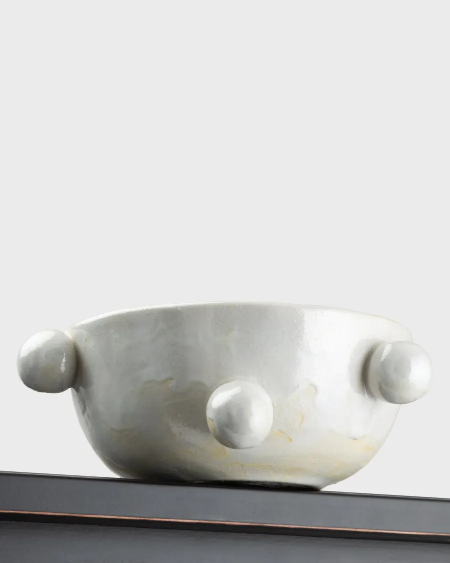 Side of the small pearl white “The Queen's Pearl Bowl” with balls on a shelf