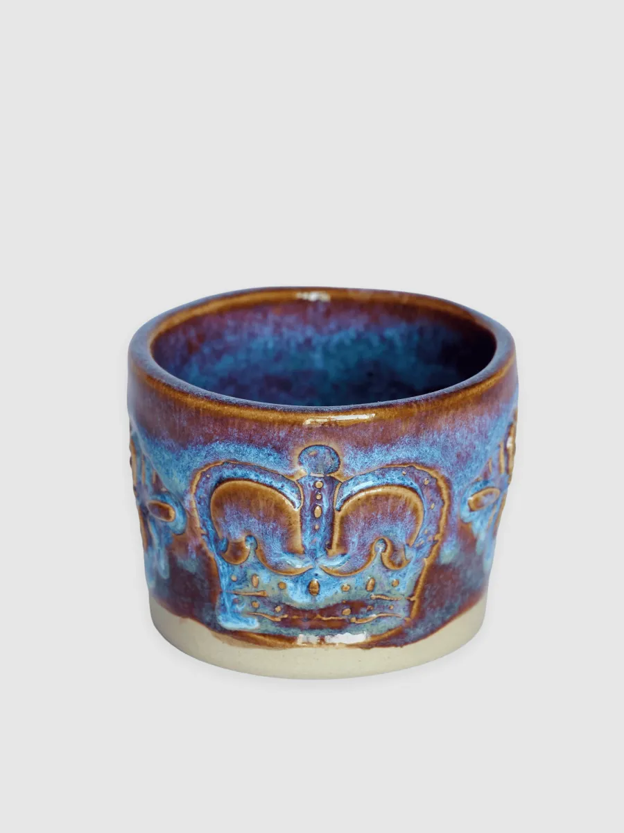Purple-glazed “Throne” espresso cup with a relief crown on a light background