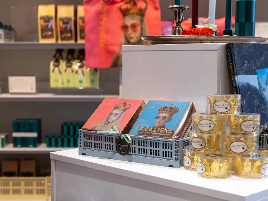 Shop table with boxes of queens' sweets, a castle-shaped basket and jars of honey