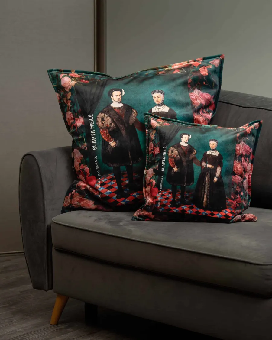 Two green cushions with a portrait of a Renaissance couple and roses on a grey sofa