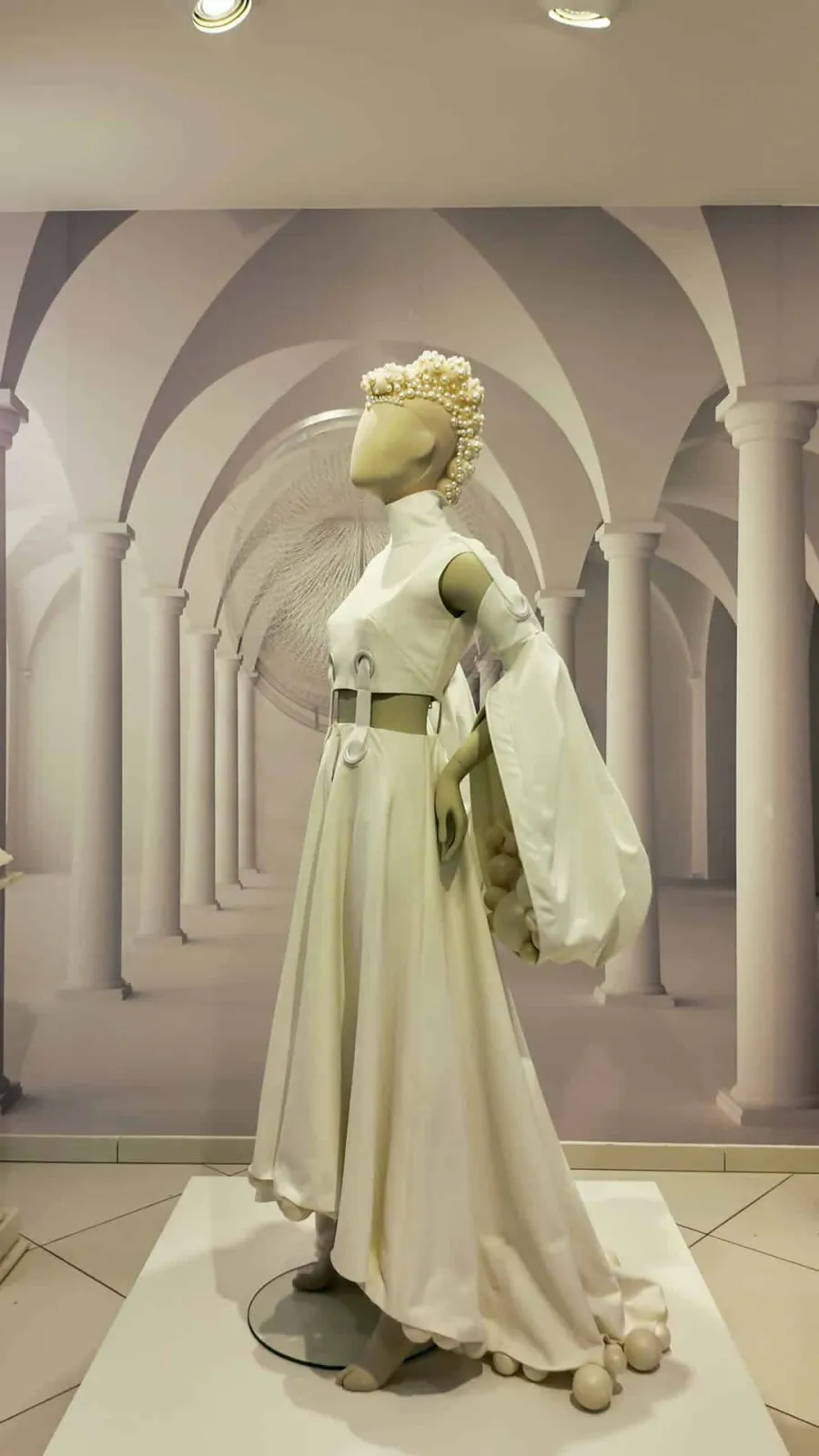White dress with a pearl crown between columns in the Balta gallery